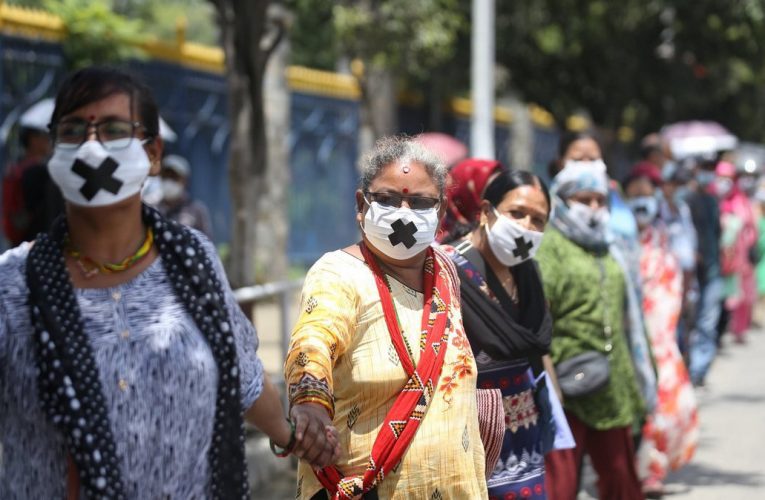 सहकारी पीडित मुखमा मास्क र कालो टेप लगाएर सडकमा